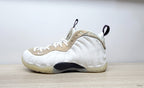 Opposite side view of a white Air Foamposite One sneaker with a dark midfoot section and marbled beige trim.