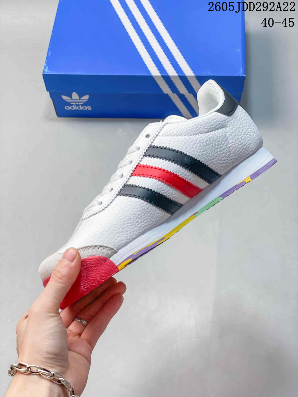 Side profile of the white adidas Samoa sneaker with black and red stripes and a multicolor outsole.