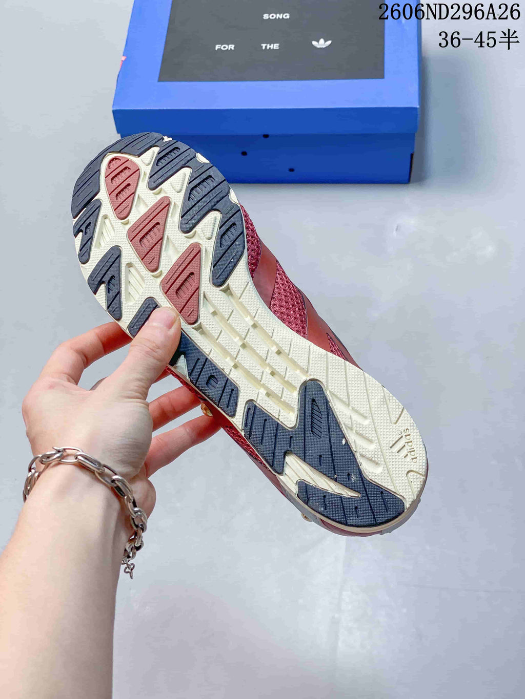Close view of the sneaker outsole showing a contrasting tread pattern with dark rubber sections and a light central area.