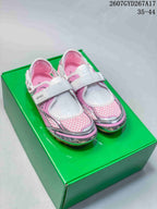 Pair of silver, white, and pink Bottega Veneta Orbit Flash sneakers displayed on a green shoebox.