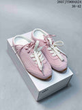 Pair of pink Alo Yoga low-top sneakers with contrasting laces displayed on a white shoebox.