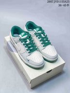 Pair of white and green Nike low-top sneakers displayed on a shoebox.