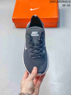 Front view of a dark gray Nike Free sneaker showing the lace-up closure, knit-textured toe, white Swoosh, and Nike Free tongue label.