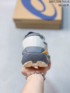 Rear view showing the padded heel, layered gray midsole, orange accent, and textured outsole.
