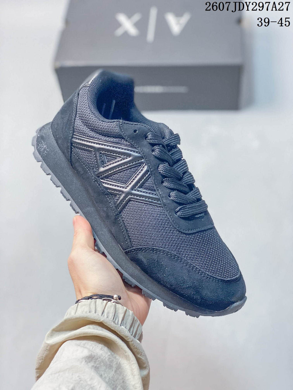 All-dark low-top sneaker with matching laces, layered panels, and a textured outsole.