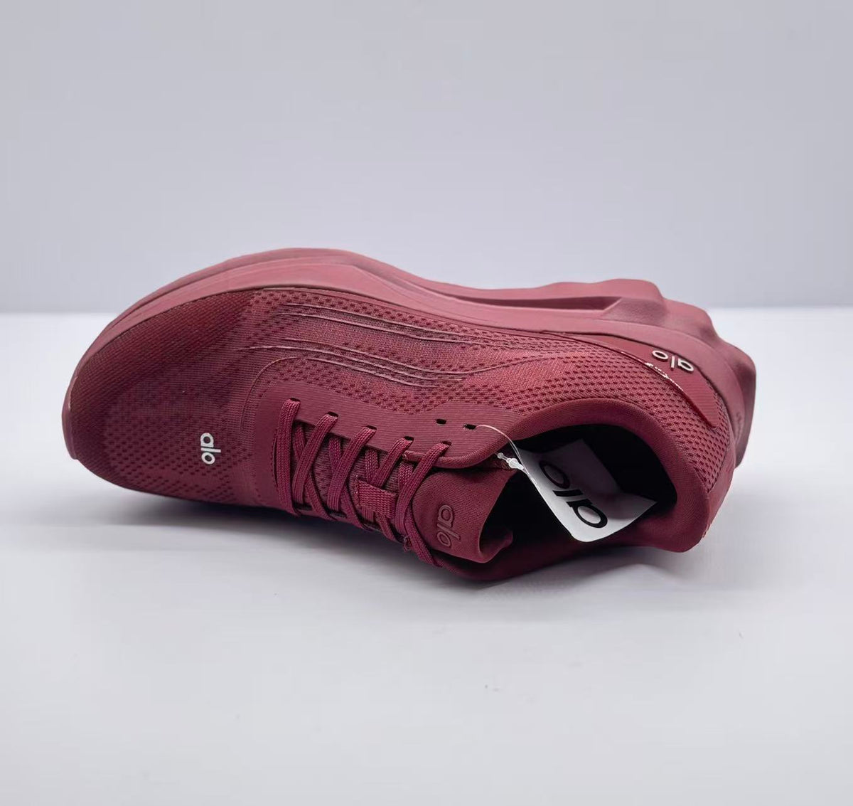 Top view of one burgundy alo Runner sneaker showing the laces, tongue, and insole tag.