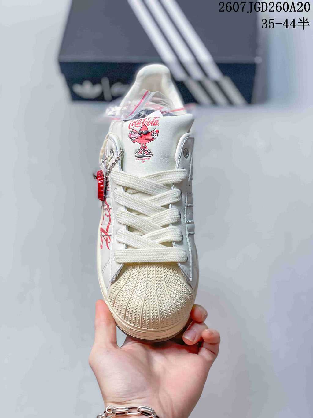 Front view showing tonal laces, textured shell toe, and Coca-Cola character artwork on the tongue.