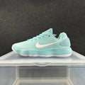 Side view of a mint-green Nike sneaker with a white Swoosh and layered ribbed midsole.