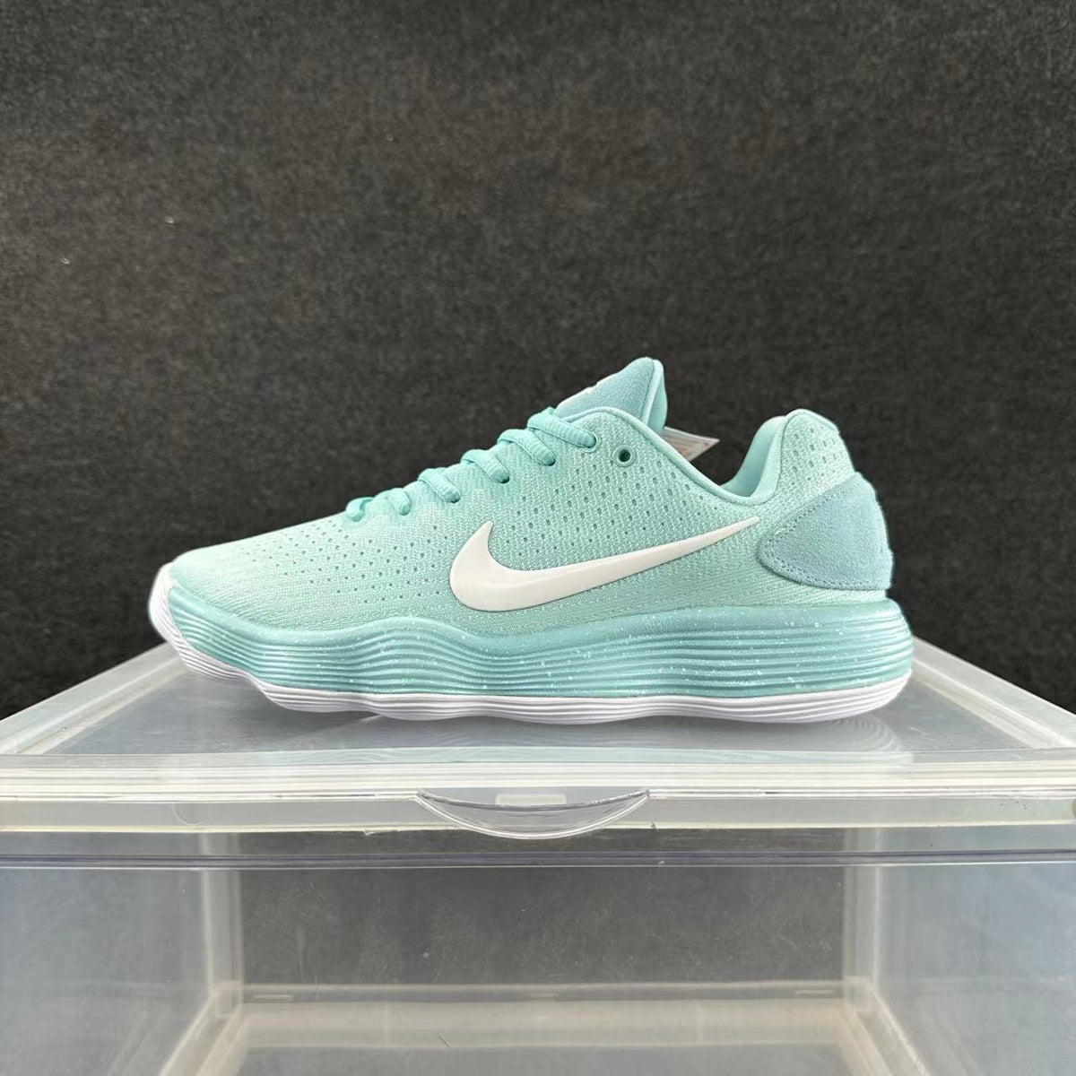 Side view of a mint-green Nike sneaker with a white Swoosh and layered ribbed midsole.