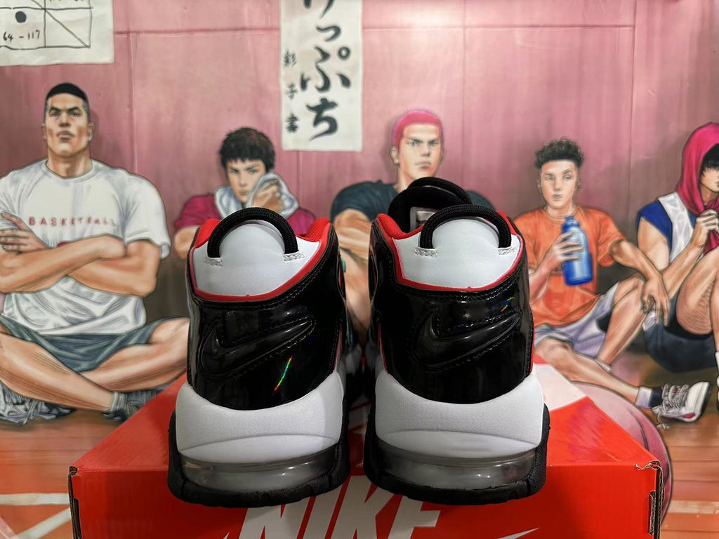 Rear view of white and black Nike basketball sneakers with red accents and visible cushioning.