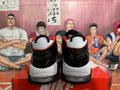 Rear view of white and black Nike basketball sneakers with red accents and visible cushioning.