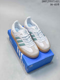 White and mint-green adidas Sambae sneakers displayed on a blue adidas shoebox.