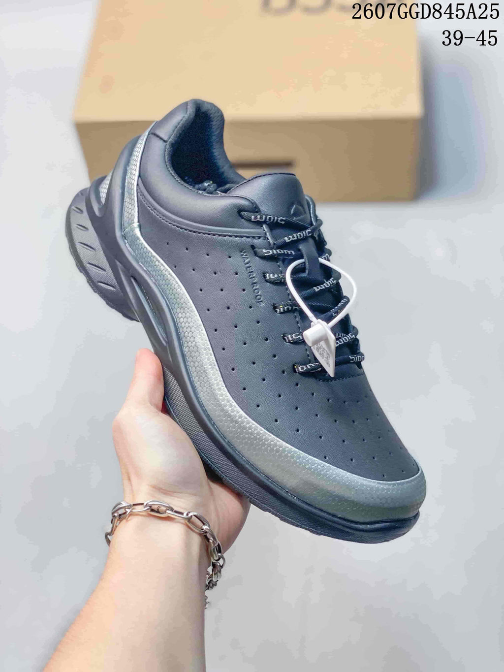 Angled side view of the black ECCO Biom sneaker showing the perforated upper, rounded toe, silver-toned side accent, and patterned outsole.