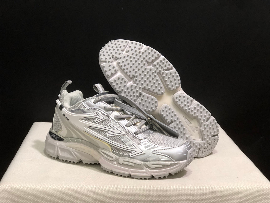 Three-quarter view with one sneaker lifted to display the textured outsole tread and the upper side graphics.