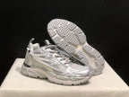 Three-quarter view with one sneaker lifted to display the textured outsole tread and the upper side graphics.