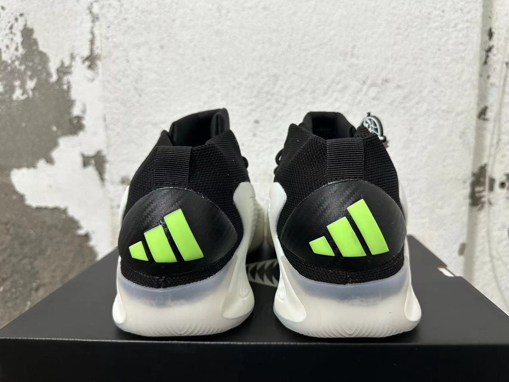 Rear view of black-and-white sneakers with bright lime heel accents and a sculpted white sole