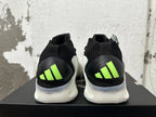 Rear view of black-and-white sneakers with bright lime heel accents and a sculpted white sole