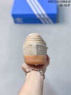 Rear view showing the woven-texture heel panels, cream detailing, and gum-colored outsole.