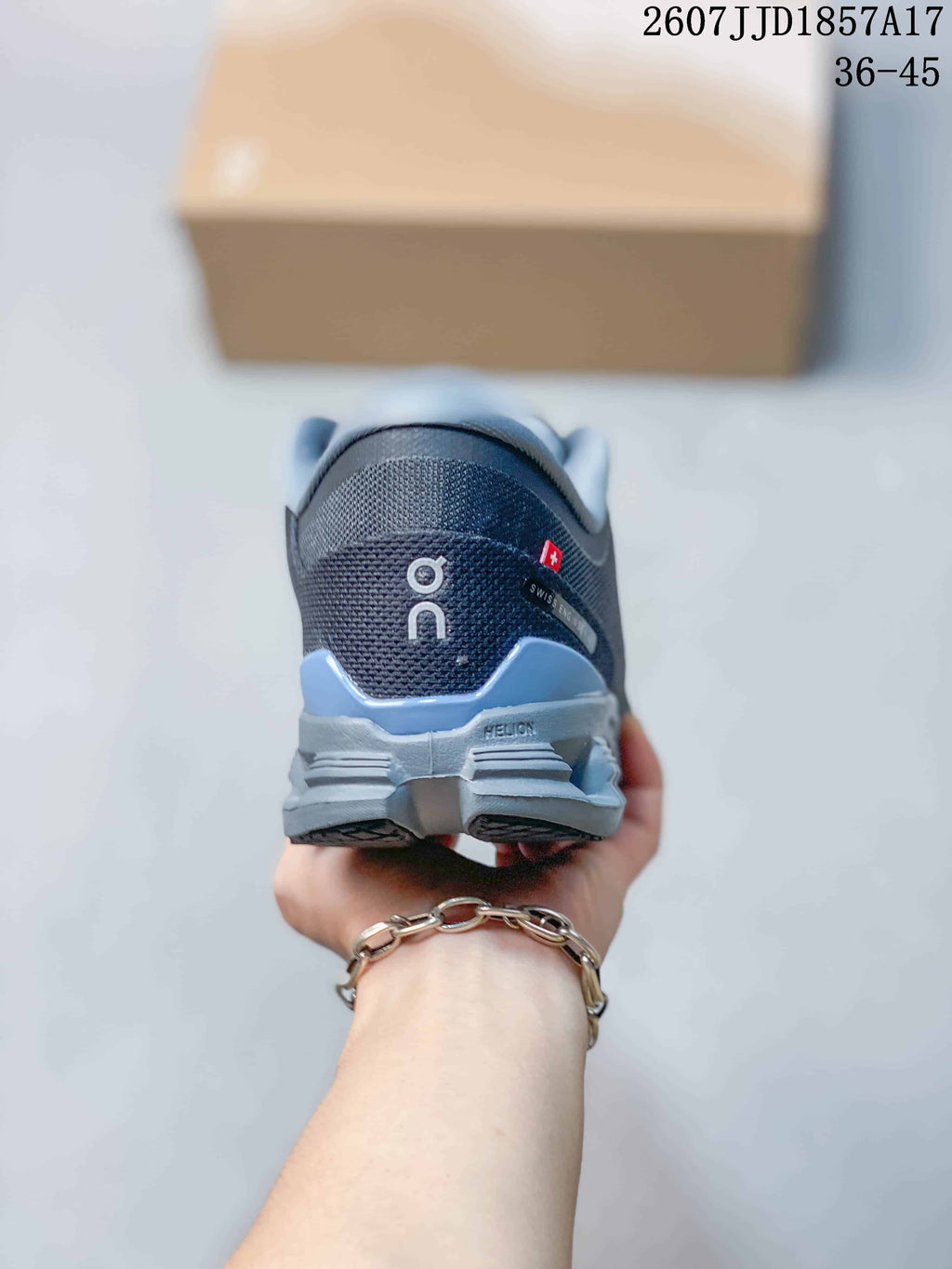 Rear view of the dark gray sneaker showing the On logo, padded collar, and layered heel sole.