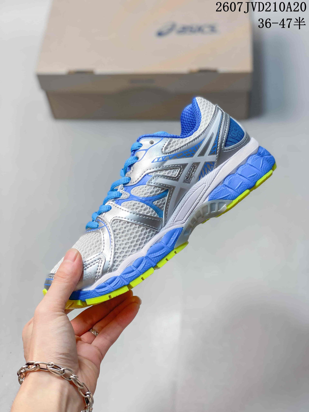 Side view showing the ASICS branding, silver-gray overlays, blue accents and segmented sole.
