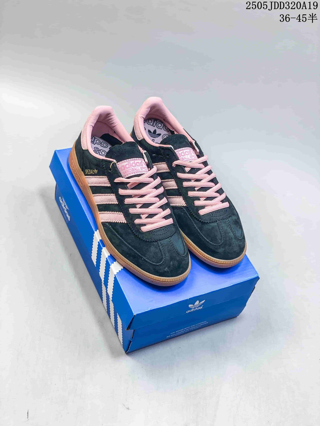 Pair of black and pink adidas low-top sneakers displayed on a blue adidas shoebox.