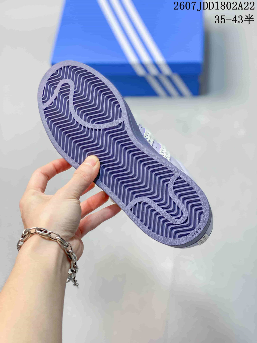 Lavender patterned rubber outsole of an Adidas Superstar sneaker shown from below.
