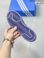 Lavender patterned rubber outsole of an Adidas Superstar sneaker shown from below.