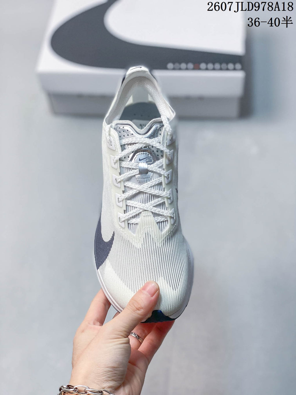Top view of a white Nike running shoe showing the textured upper, lace system, tongue, and dark navy Swoosh.