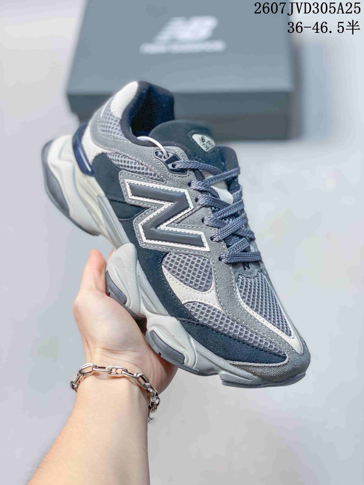 Angled side view showing the grey and navy upper, N branding, laces, and chunky sole.