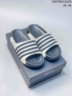Pair of navy and white ECCO slide sandals displayed on a branded box; style code 2607ND515A25 and size range 36–46 are visible.