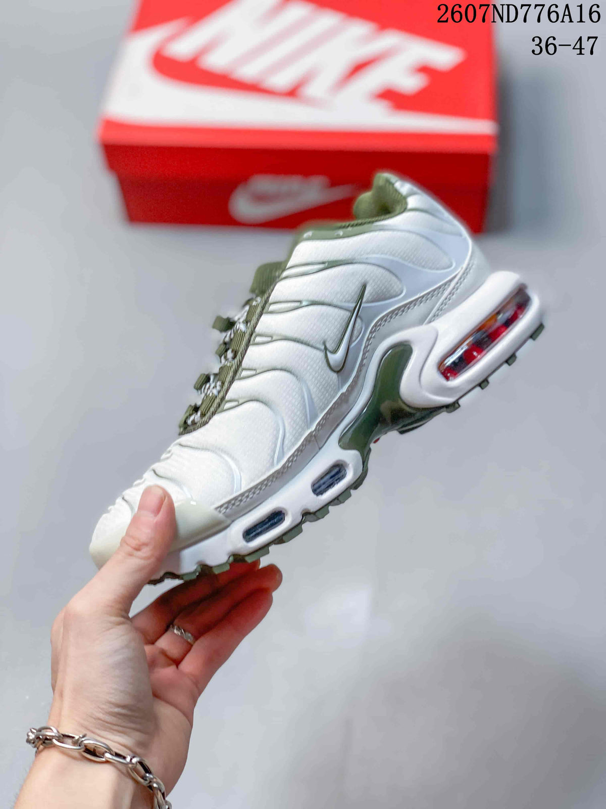 Side view of the white and green sneaker showing layered panels, side swoosh branding, and visible midsole air units.