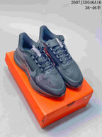 Pair of black and gray Nike Zoom sneakers displayed on an orange shoebox.