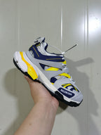 Close angled view of the Balenciaga Track sneaker showing the layered upper, mesh sections, yellow accents and black lugged outsole.
