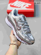 Angled side view of the silver and white Nike P-6000 sneaker with layered overlays and rubber outsole.