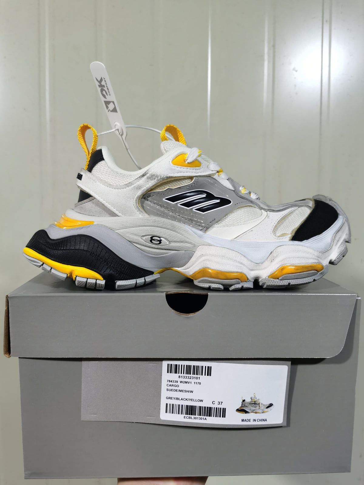 Side profile of the sneaker displayed on its box; the box label shows model 1170, color text, and sample size 37.