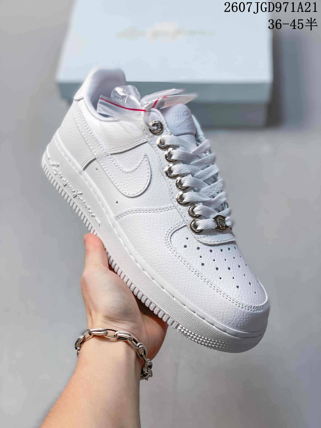 Angled side view of the white Nike low-top sneaker showing the Swoosh, perforated toe, and textured outsole.