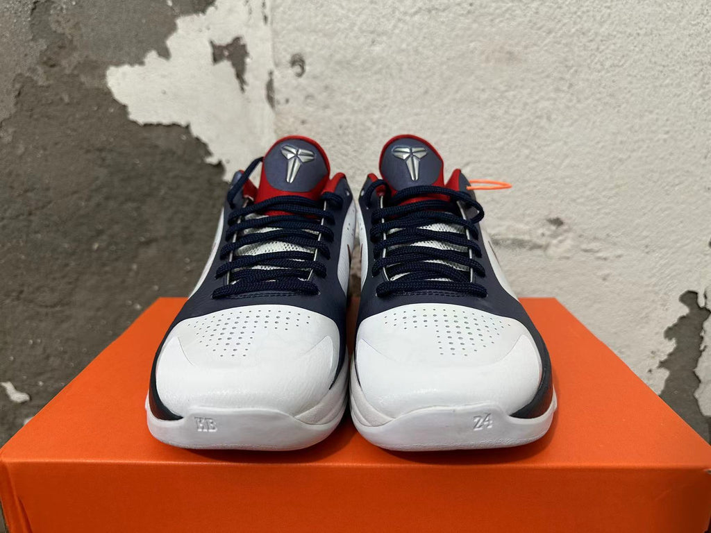 Front view of white, navy, and red Nike Kobe basketball shoes with perforated toe panels