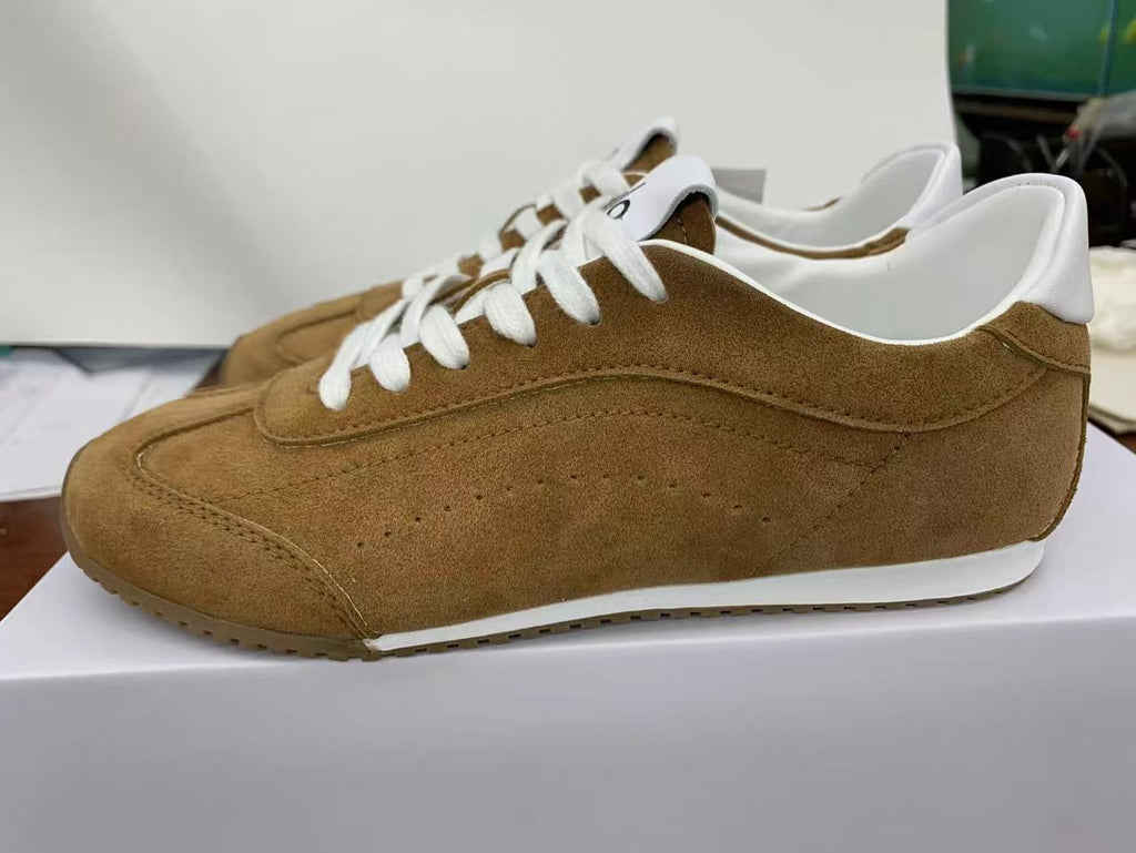 Side view of brown Alo low-top sneakers with white laces, white collar accents, and a white midsole.