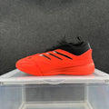 Side view of red-orange and black low-top lace-up sneakers with three black stripes and a matching outsole.
