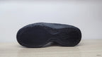 Bottom view showing the dark patterned outsoles of the sneakers.