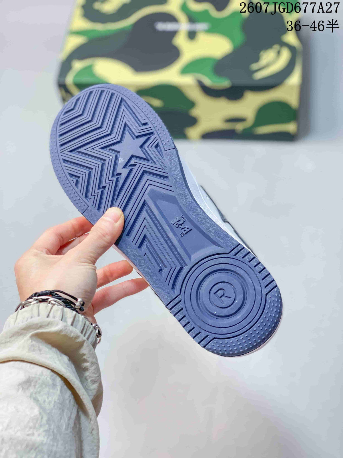 Blue patterned outsole of a BAPE Sta sneaker shown from below, with the camouflage shoebox in the background.