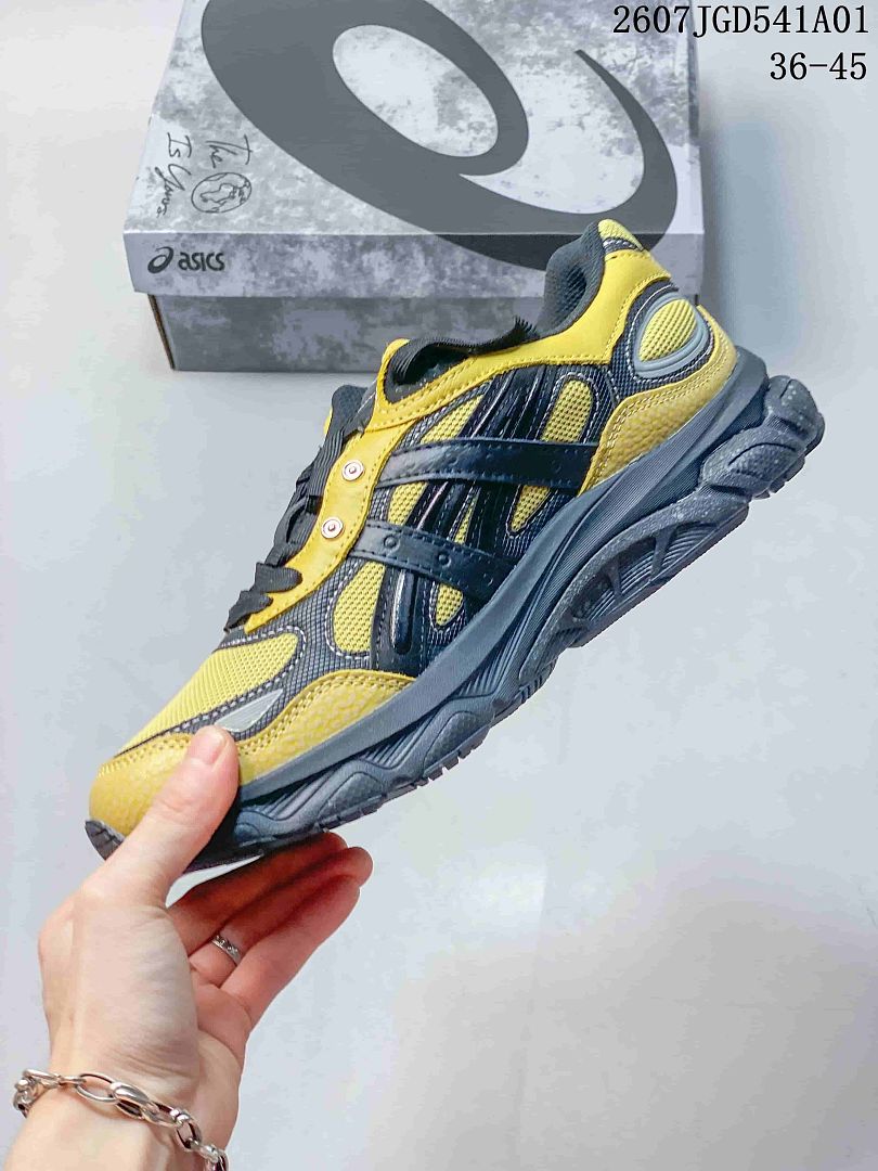 Side profile of the yellow and charcoal sneaker with layered panels
