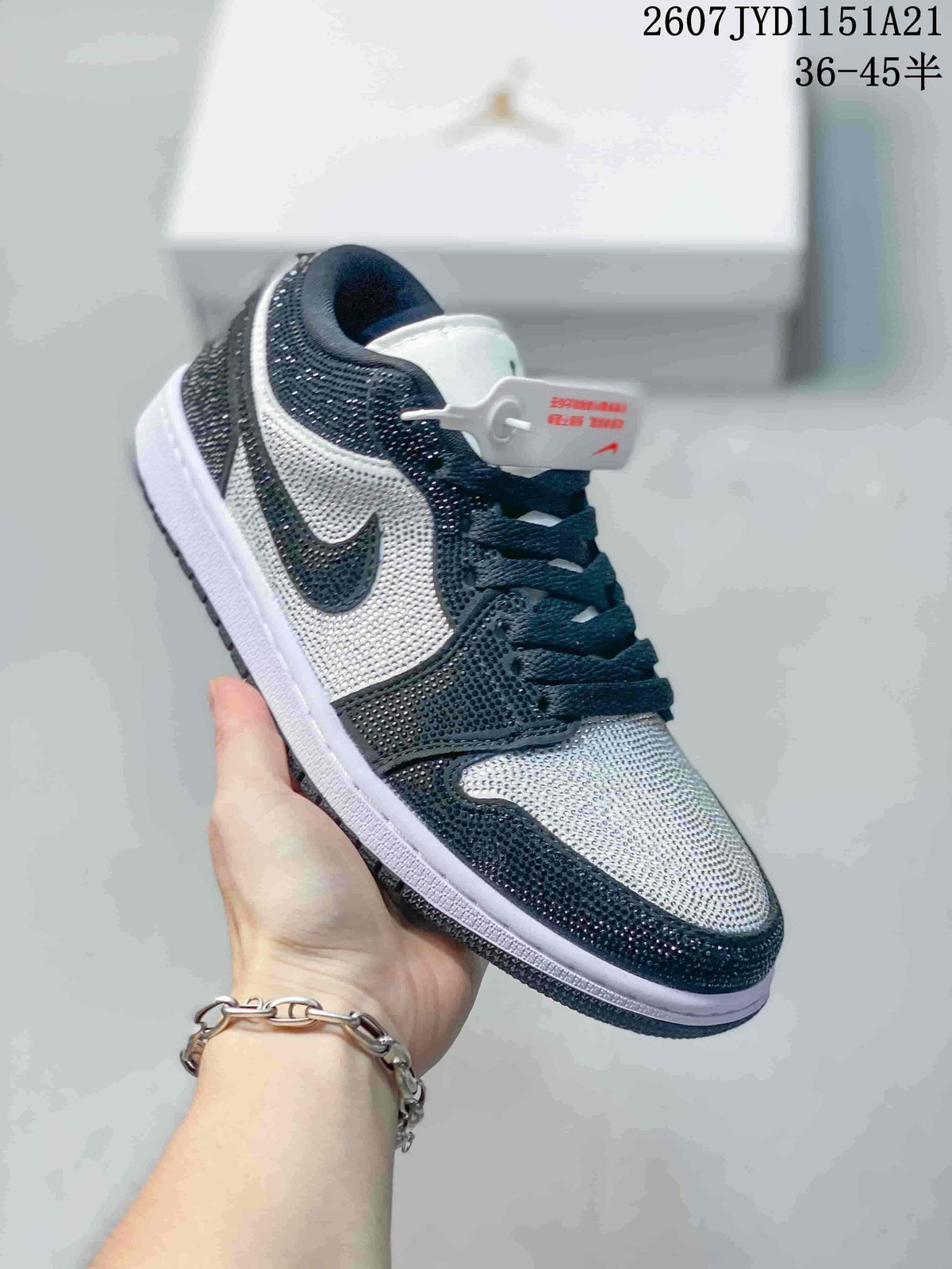 Angled side view highlighting the black and white upper, reflective studded embellishment, side Swoosh, laces, and layered sole.