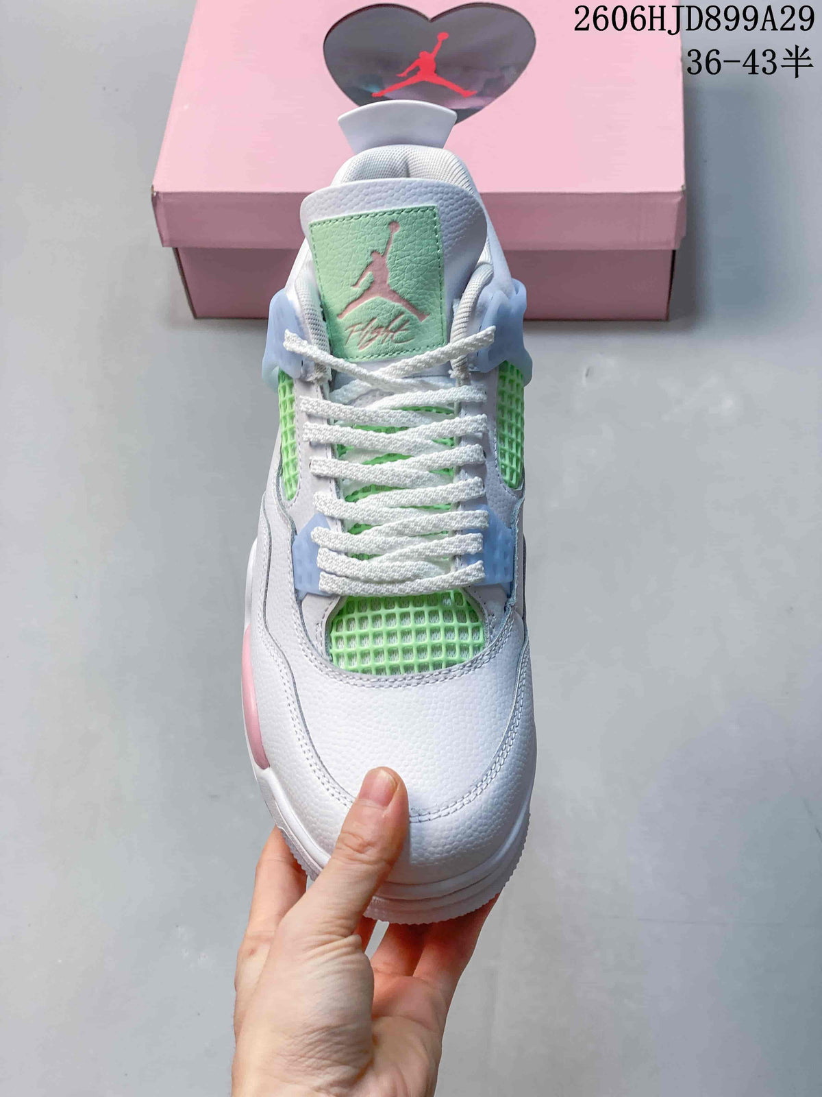 Front view of a white Air Jordan 4 Retro sneaker with mint green mesh and a pale green tongue panel