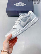 Side view of a white and light grey low-top sneaker with a swoosh-shaped panel and graphic accents.