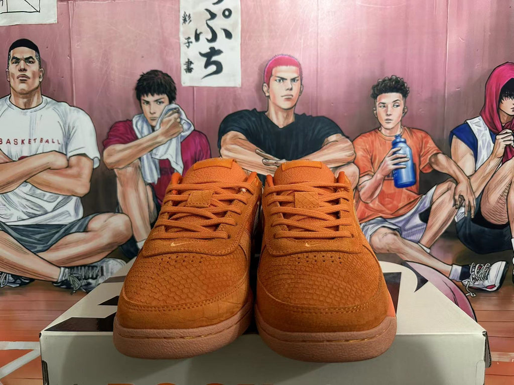 Front view of orange Nike low-top sneakers with tonal laces and textured toe panels