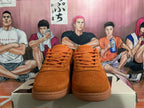 Front view of orange Nike low-top sneakers with tonal laces and textured toe panels