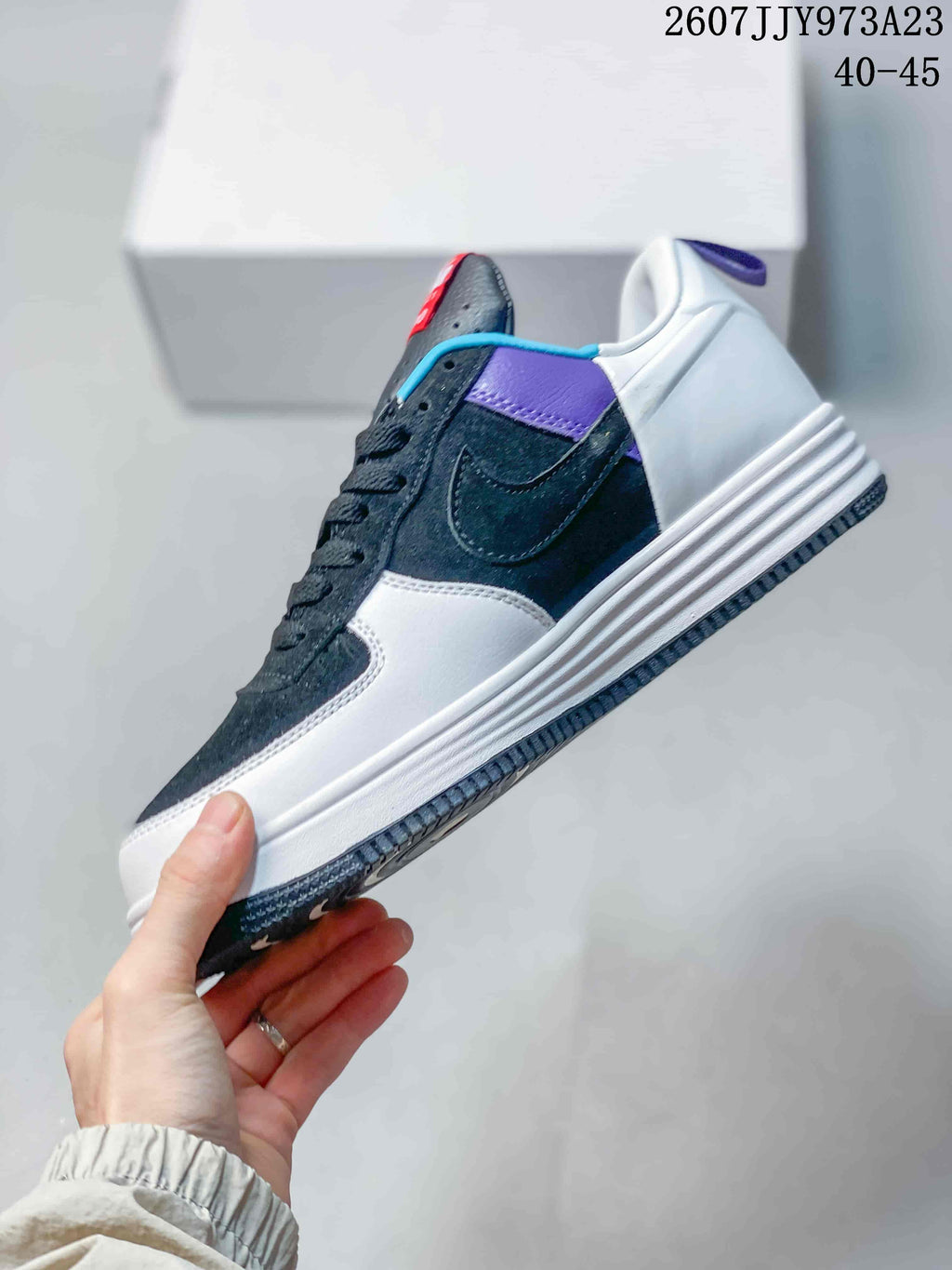 Side view showing the dark upper, white side panel, Nike Swoosh, purple accent, and layered white sole.