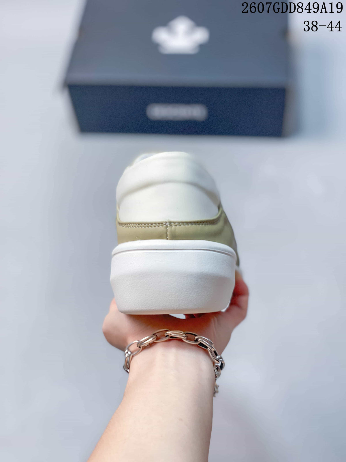 Rear view of the beige sneaker showing the padded white collar and raised white heel sole.