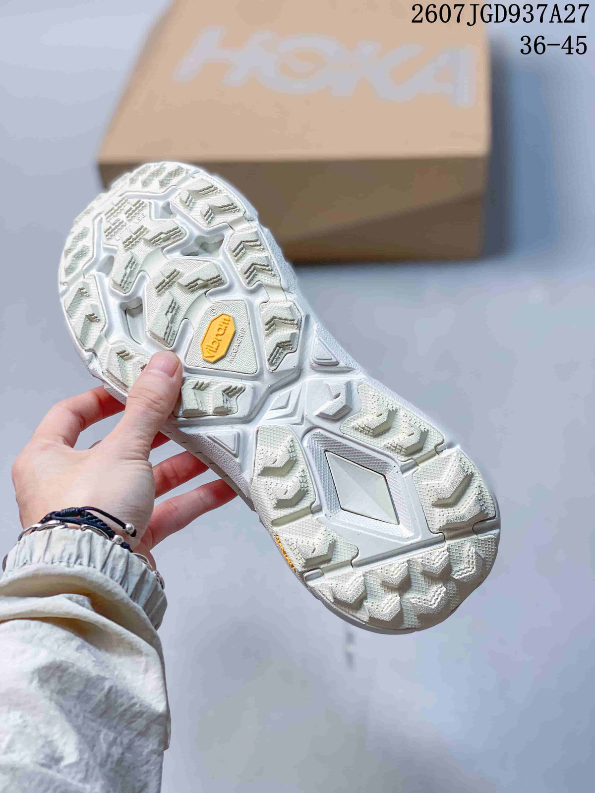 Underside view showing the textured white outsole with a contrasting central insert and yellow accent.